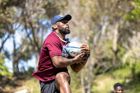 Le champion de rugby Siya Kolisi attrape le ballon lors d'un entraînement.