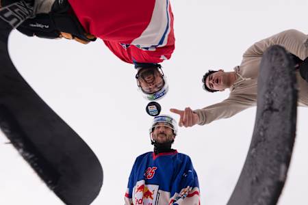 Hockeyspieler versammle sich um s Bully uf ere Iisbahn im Freie.