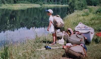 Young Benny Marr stood by canoe and camping kit.