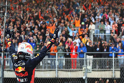 Max Verstappen celebrates his 2023 Dutch Grand Prix victory for Oracle Red Bull Racing in parc fermé at Circuit Zandvoort, raising his arms before a jubilant home crowd.