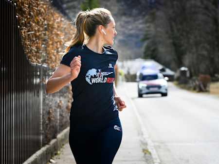 Wings for Life World Run Teilnehmerin trainiert mit der Wings for Life World Run App und wird dabei vom Catcher Car jagt.