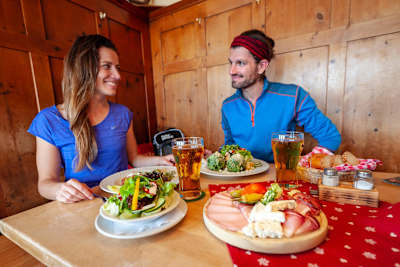 A couple sit down at a table to enjoy traditional Tyrolean food in Innsbruck.