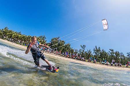 Ruben Lenten riding by the camera and making a peace sign in Le Morne, Mauritius.