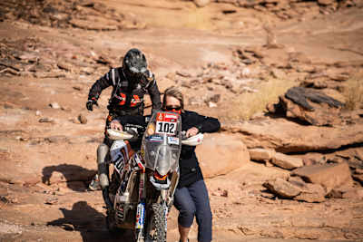 Photo of Jutta Kleinschmidt assisting French bike Sara Jugla at the 2021 Dakar Rally