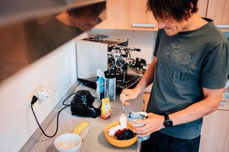 Triathlet Sebastian Kienle bereitet sich in seiner Küche ein Porridge zum Frühstücken vor.