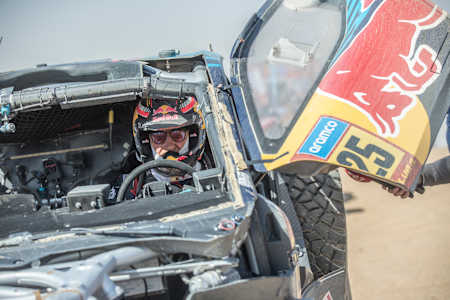 Carlos Sainz en el coche de rally Red Bull Ford en la línea de meta de la etapa 2025 del Rally Dakar.