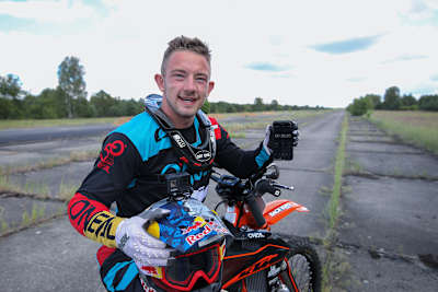 FMX-Weltmeister Luc Ackermann mit dem Smartphone, das seine Weltrekordzeit zeigt.