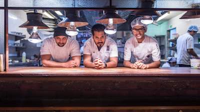 Chef Thomas Zacharias poses in his kitchen with his staff besides him