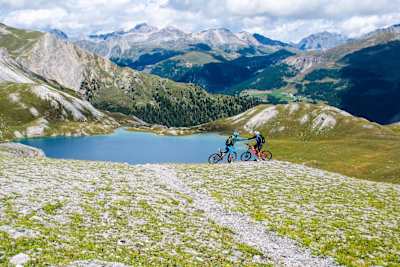 Zwei Mountainbiker geben sich die Faust während einer MTB Tour am Piz Umbrail am STILFSER JOCH.