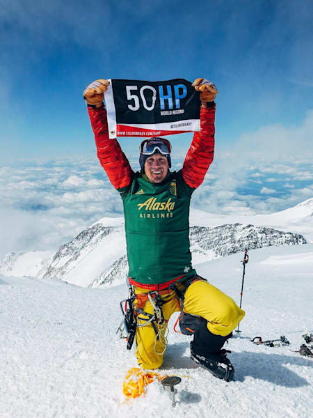 Adventurer Colin O'Brady holds up a 50HP banner at the peak of Denali in Alaska during his record-breaking summiting of the highest point in all 50 states of the USA in 21 days.