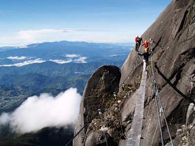 People cross the bridge on the via ferrata on Mount Kinabalu.