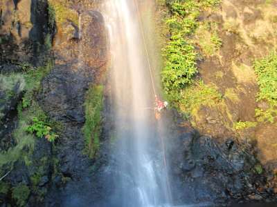 A person abseils down a waterfall on one of the islands on the Azores.