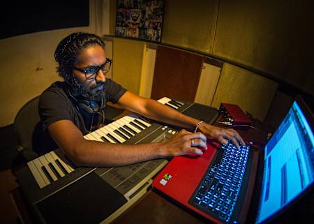 Emiway Bantai working on a computer while recording his songs