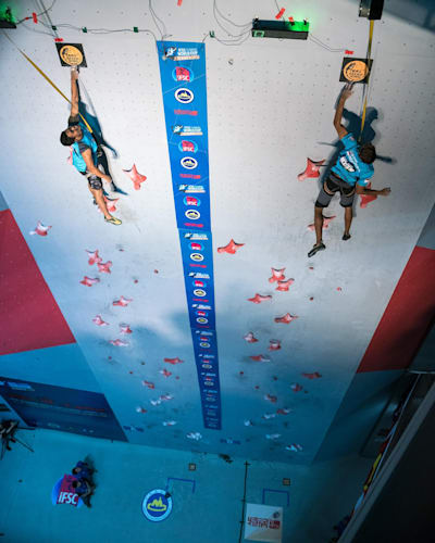 Dos participantes se enfrentan durante una carrera de escalada rápida.