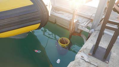 A photo of the Seabin ocean trash can in action in a harbour.