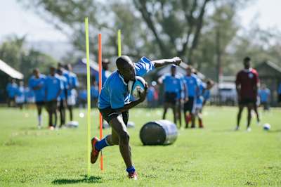 A young rugby player is training.