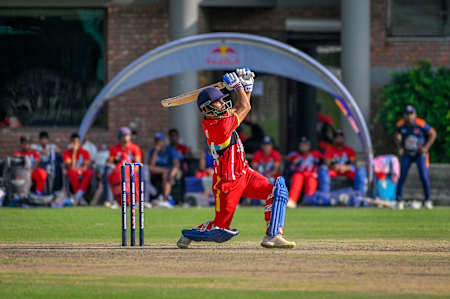 2023 Red Bull Campus Cricket Ligi maçı sırasında Hindistan'ın Dehradun kentindeki Abhimanyu Kriket Akademisi Stadyumu'nda bir vurucunun güçlü bir vuruş gerçekleştirdiği an.