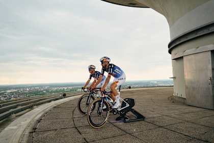 Florian Lipowitz und Remco Evenepoel präsentierten das umgedrehte Tour de France Trikot auf dem Münchner Olympiaturm.