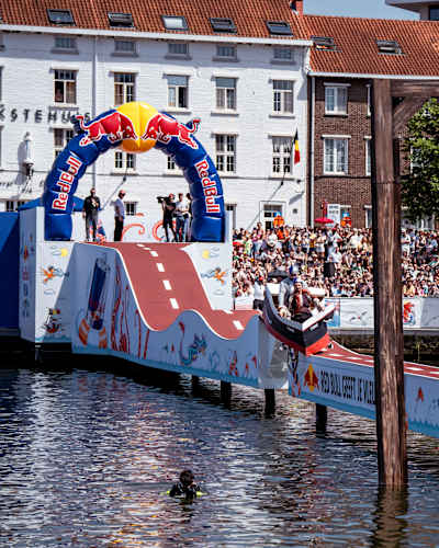 Participants showcase their wild creations during Red Bull Vél'Eau 2026 in Hasselt, Belgium, launching imaginative vehicles from a ramp into the water as crowds cheer them on
