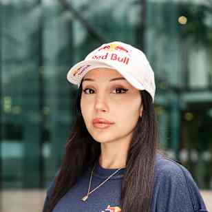 In 2025, Samira Elquaria sports branded Red Bull apparel during a dynamic portrait shoot in Fuschl, Salzburg, capturing the adventurous energy of the brand.
