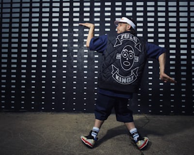 Greenteck is standing with his back to us showing crew colours on the back of his jacket.