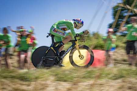 Maillot vert sur le dos, Wout van Aert donne tout lors d’un contre-la-montre du Tour de France, sous les encouragements d’un public vêtu de vert.