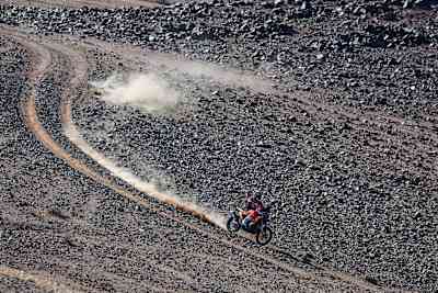 In 2024, Kevin Benavides of Red Bull KTM Factory Racing races his motorcycle, kicking up dust on the rugged Dakar Rally course near Al Ula, Saudi Arabia.