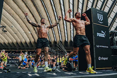Les athlètes Jake Dearden et Marc Dean franchissent la ligne d'arrivée et remportent la victoire en catégorie relais du championnat du monde Hyrox 2024 à Nice, en France.