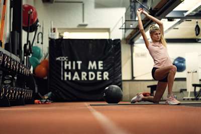 Konstanze Klosterhalfen estira en el dinámico Centro de Rendimiento de Atletas Red Bull de Thalgau, Austria, durante su intensa sesión de entrenamiento en noviembre de 2023.