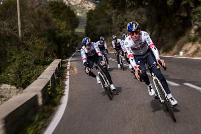Alexander Hajek und das Red Bull - BORA -hansgrohe Team navigieren während ihres Mallorca-Trainingslagers im Januar 2025 durch scharfe Kurven und demonstrieren dabei Präzision und Teamwork.