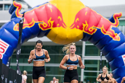 Two women running alongside each other at a HYROX fitness race