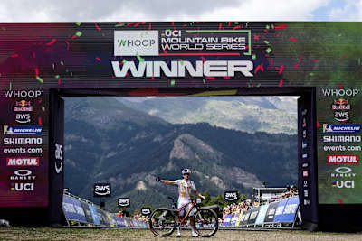 Tom Pidcock celebrates victory at the UCI Mountain Bike World Cup finish line in Pal Arinsal, Andorra, on July 12, 2025, showcasing peak racing adrenaline