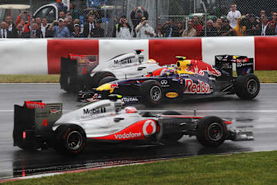 Lewis Hamilton en teamgenoot Jenson Button rijden aan weerszijden van Mark Webber als hij spint tijdens de Canadese Formule 1 Grand Prix op het Circuit Gilles Villeneuve in Montreal, Canada.
