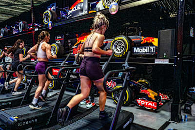 Participants push their limits on treadmills surrounded by Red Bull Racing cars at the Red Bull HYROX Coaches Camp, Silverstone Circuit, UK, on August 5, 2025, during an energetic brand experience.