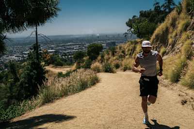 German ultrarunner Arda Saatçi runs through a rugged Los Angeles trail. 