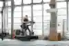 Pro fitness athlete Laura Horváth is running on a treadmill in a gym 