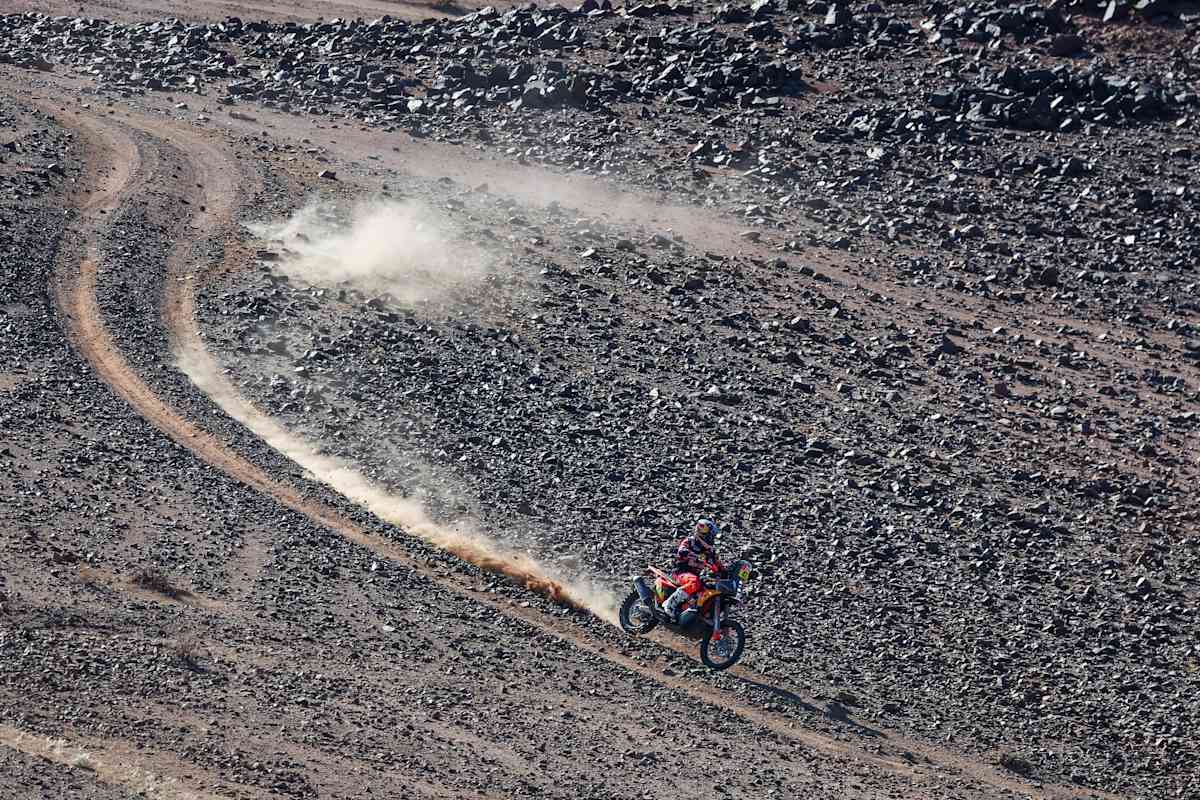 En 2024, Kevin Benavides de Red Bull KTM Factory Racing corre con su moto, levantando polvo en el accidentado recorrido del Rally Dakar cerca de Al Ula, Arabia Saudí.