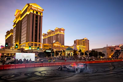 Sergio Pérez drives an Oracle Red Bull Racing car in front of Caesars Palace.