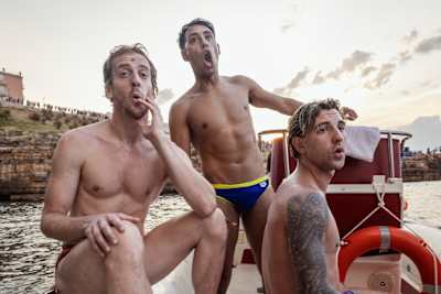Gary Hunt (L), Sergio Guzman (C) and Nikita Fedotov (R) react after watching a dive during the third stop of the Red Bull Cliff Diving World Series in Polignano a Mare, Italy on July 01, 2023.