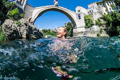 Diver Rhiannan Iffland smiling in water underneath large bridge.