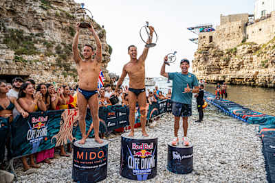 In 2024, James Lichtenstein, Constantin Popovici and Jonathan Paredes celebrate at Red Bull Cliff Diving World Series in Polignano a Mare, Italy.