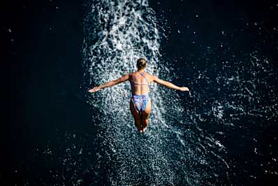 Rhiannan Iffland dives gracefully into deep waters below the iconic cliffs in Antalya at the 2024 Red Bull Cliff Diving World Series