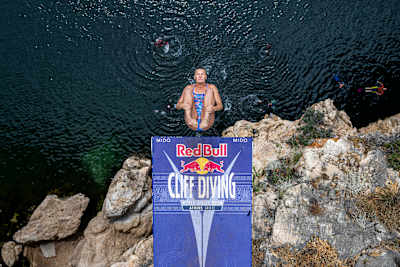 Rhiannan Iffland somersaulting during a dive at Lke Vouliagmeni in Athens at the 2024 Red Bull Cliff Diving World Series season opener.