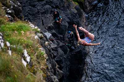 In 2024, Rhiannan Iffland dives off a cliff at Dunluce Castle during the Red Bull Cliff Diving World Series event