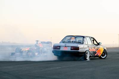 In 2024, David Coulthard and Samkeliso Thubane drift Red Bull Racing cars at Kyalami circuit in Johannesburg, South Africa, leaving trails of smoke behind them.