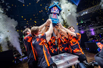 Los jugadores de Fnatic celebran su victoria levantando el trofeo Red Bull Home Ground entre confeti y humo en la final del torneo en Tokio, Japón.