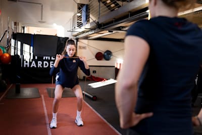 Turkish volleyball player Hande Baladin performs an exercise with a rubber band during training.