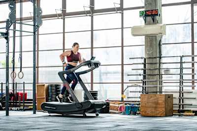Laura Horváth, athlète professionnelle de fitness, s'entraine sur un tapis de course dans une salle de sport. 