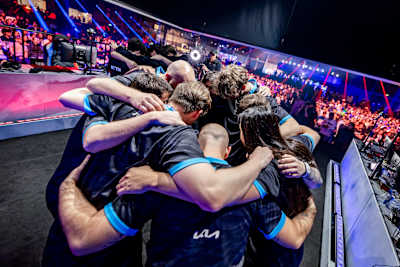 Teams T1 and Cloud9 gather in pre-game huddles at Red Bull Home Ground 2024 in Berlin, Germany, as the vibrant crowd anticipates top-tier esports action