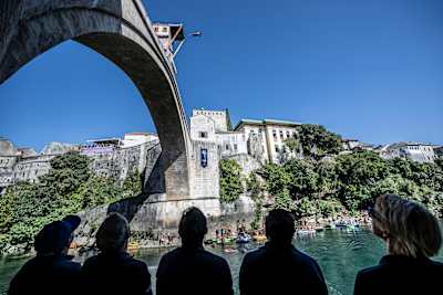 In Mostar, Bosnia and Herzegovina, during the 2023 Red Bull Cliff Diving World Series, Oleksiy Prygorov plunges from Stari Most bridge as spectators watch intently